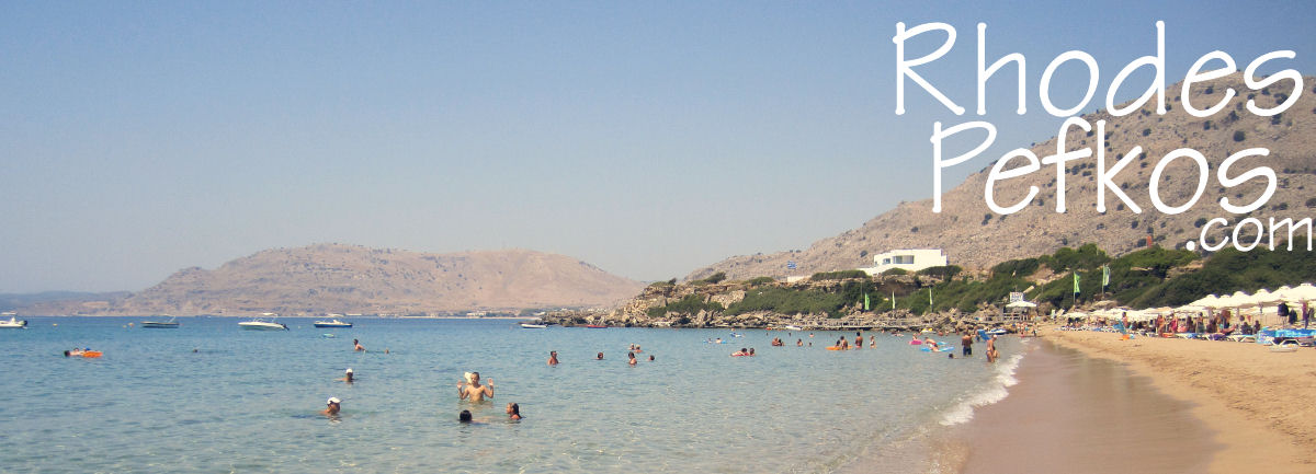 View along Lee Beach Pefkos with clear water and people swimming